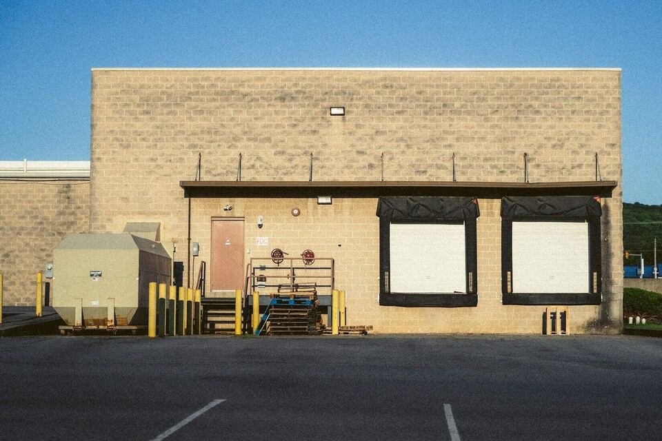 Warehouse wall with two loading dock doors on a sunny day