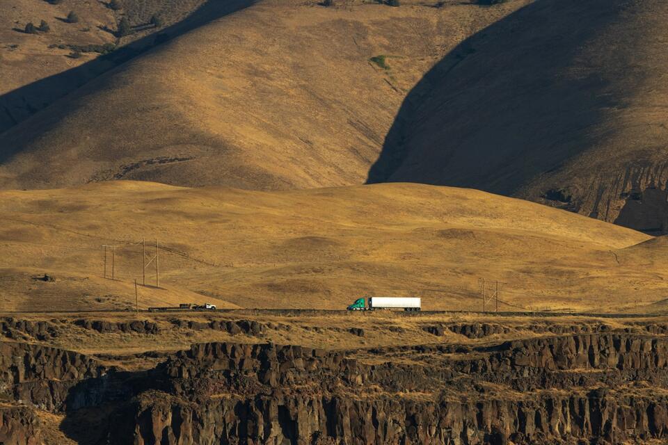 Tractor-trailer crossing golden hills on a long-haul route